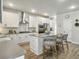 Bright kitchen with white cabinets, stainless steel appliances, an island with bar stool seating, and wood grain floors at 4310 Cotton Flat Rd, Summerville, SC 29485