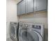 Well-equipped laundry room with modern appliances and gray cabinets, and stylish floor tiles at 4332 John Hatch Dr, Johns Island, SC 29455