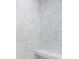 Close up of an elegant walk-in shower with white marble style tiling and built in bench at 4332 John Hatch Dr, Johns Island, SC 29455