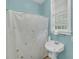 Cozy bathroom featuring a pedestal sink and floral shower curtain by a window at 4584 Olde Smoak House Rd, Meggett, SC 29449