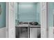 Bright laundry room features a washer and dryer set with white shelving, and pastel blue walls at 4584 Olde Smoak House Rd, Meggett, SC 29449
