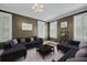 Comfortable living room with a large sofa, shutters, and elegant chandelier at 4584 Olde Smoak House Rd, Meggett, SC 29449