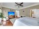 A spacious main bedroom with hardwood floors, a ceiling fan, and a large tv at 4584 Olde Smoak House Rd, Meggett, SC 29449