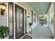 Charming home porch with a decorative front door, cozy swing, and stylish outdoor lighting at 4584 Olde Smoak House Rd, Meggett, SC 29449