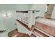 Stylish staircase with wood steps, white spindles, and decorative rug at the landing at 4584 Olde Smoak House Rd, Meggett, SC 29449