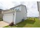 View of the home's gray vinyl siding exterior, showcasing a two-car garage and well-manicured lawn at 470 Spectrum Rd, Summerville, SC 29486