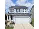 Charming two-story home featuring a well-maintained front yard, a two-car garage, and blue vinyl siding at 470 Spectrum Rd, Summerville, SC 29486