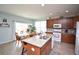 Open-concept kitchen featuring granite island, cabinetry, stainless sink, and connecting dining area at 470 Spectrum Rd, Summerville, SC 29486