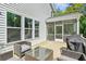 Inviting back deck featuring wicker furniture, a glass table, grill, and a screened-in porch for relaxing outdoors at 5035 Gum Tree Ln, Johns Island, SC 29455