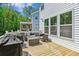 Inviting back deck featuring wicker furniture, a glass table, grill, and backing to forest at 5035 Gum Tree Ln, Johns Island, SC 29455