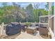 Inviting back deck featuring wicker furniture, a glass table, grill, and backing to forest at 5035 Gum Tree Ln, Johns Island, SC 29455