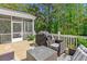Inviting back deck featuring wicker furniture, a glass table, grill, and backing to forest at 5035 Gum Tree Ln, Johns Island, SC 29455