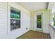 Relaxing covered porch with wood flooring, white siding, and a screened-in door at 5035 Gum Tree Ln, Johns Island, SC 29455