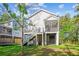 Exterior rear view of a home featuring a deck and screened in porch above the shaded backyard space at 5035 Gum Tree Ln, Johns Island, SC 29455