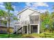 Exterior rear view of a home featuring a deck and screened in porch above the shaded backyard space at 5035 Gum Tree Ln, Johns Island, SC 29455