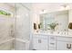 Well-lit bathroom featuring double sinks, white cabinetry, and a large mirror at 5035 Gum Tree Ln, Johns Island, SC 29455