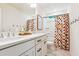 Bright bathroom with double sink vanity, black hardware, and colorful shower curtain at 5035 Gum Tree Ln, Johns Island, SC 29455