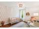 Charming Bedroom with a crib, accent wall, decorative chandelier, and hardwood floors at 5035 Gum Tree Ln, Johns Island, SC 29455