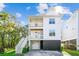 Bright, modern three-story house featuring double balconies and staircase leading to a garage at 5035 Gum Tree Ln, Johns Island, SC 29455