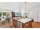 Kitchen island with seating and sink, flowing into dining and living areas with hardwood floors at 5035 Gum Tree Ln, Johns Island, SC 29455