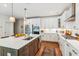 Bright kitchen with white cabinets, stainless appliances, expansive island, and hardwood flooring at 5035 Gum Tree Ln, Johns Island, SC 29455