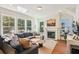Bright living room features large windows, fireplace, and hardwood floors, creating a cozy and inviting atmosphere at 5035 Gum Tree Ln, Johns Island, SC 29455