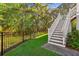 Well-maintained yard with metal fence and staircase to the home entrance at 5035 Gum Tree Ln, Johns Island, SC 29455