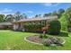 Landscaped front yard featuring a brick home, green lawn, and a flower bed at 65 University Dr, Ladson, SC 29456