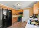 Functional kitchen features wooden cabinets, a black refrigerator, and stainless steel appliances at 65 University Dr, Ladson, SC 29456