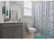 Bright bathroom features a gray vanity and a shower/tub combo with stylish patterned curtain at 706 Squire Pope Rd, Summerville, SC 29486