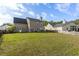 Large, grassy backyard with a fenced perimeter and view of the home's exterior at 712 Bent Hickory Rd, Charleston, SC 29414