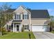 Charming two-story home featuring a well-manicured lawn, attached garage, and classic black shutters at 712 Bent Hickory Rd, Charleston, SC 29414
