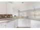 Bright kitchen area with white cabinetry, stainless steel dishwasher, and a partial view to the living area at 712 Bent Hickory Rd, Charleston, SC 29414