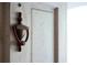 Close-up of a decorative door knocker on a weathered white door, adding character and charm at 731 Pitt St, Mount Pleasant, SC 29464