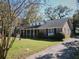 An expansive exterior view of the brick home featuring a large lawn and covered front porch at 731 Pitt St, Mount Pleasant, SC 29464