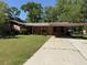 Traditional brick home featuring a red carport and well-maintained front lawn at 7724 Linsley Dr, North Charleston, SC 29418