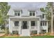 Inviting two-story home boasts a metal roof, white exterior, and welcoming front porch with stylish columns at 791 Hughes Rd, Johns Island, SC 29455