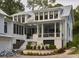 Stunning two-story home with white siding, black-framed windows, metal roof and a beautiful outdoor living space at 791 Hughes Rd, Johns Island, SC 29455