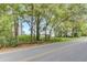 Street view of an older house with overgrown weeds and grass and plenty of trees at 791 Hughes Rd, Johns Island, SC 29455