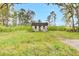 Image of an older house with overgrown weeds and grass and plenty of trees at 791 Hughes Rd, Johns Island, SC 29455