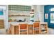 Bright kitchen features a central island with open shelving, white tile backsplash, and modern appliances at 791 Hughes Rd, Johns Island, SC 29455