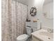 Cozy bathroom featuring a toilet, a neutral seashell shower curtain and decorative wreath and oval mirror at 8 Duffers Ct. # A, Charleston, SC 29414