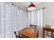 Cozy dining nook with a wood table, chairs, window with striped curtains, and pendant lamp at 8 Duffers Ct. # A, Charleston, SC 29414