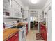 White appliances and cabinetry in a galley kitchen with wood countertops and tile floors at 8 Duffers Ct. # A, Charleston, SC 29414