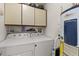 Practical laundry room with washer, dryer, storage cabinets and water heater for efficient home management at 8 Duffers Ct. # A, Charleston, SC 29414