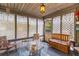 Relaxing sun room features a glass table, chairs, wood ceiling, and screened windows, creating a serene retreat at 8 Duffers Ct. # A, Charleston, SC 29414