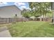 Spacious grassy backyard enclosed by a wooden fence with mature trees and greenery at 8001 Hydrangea Ln, Hanahan, SC 29410
