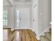 Bright foyer with hardwood floors, staircase, coat closet, and front door with glass features at 8001 Hydrangea Ln, Hanahan, SC 29410