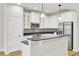 A modern kitchen with white cabinets, stainless steel appliances, and a dark countertop breakfast bar at 8001 Hydrangea Ln, Hanahan, SC 29410