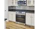 Close-up of a modern kitchen with stainless steel appliances, granite countertops, and white cabinets at 8001 Hydrangea Ln, Hanahan, SC 29410